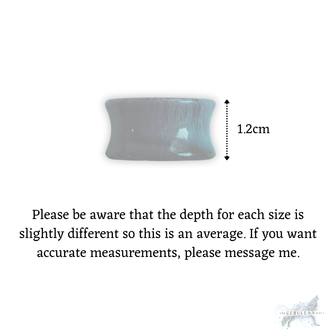 A grey, cylindrical ring-shaped object represents The Cerulean Wolfs Midnight Mist Double Flared Plugs, with an arrow showing a 1.2 cm height. Depth may vary; request exact measurements for these plugs if needed.
